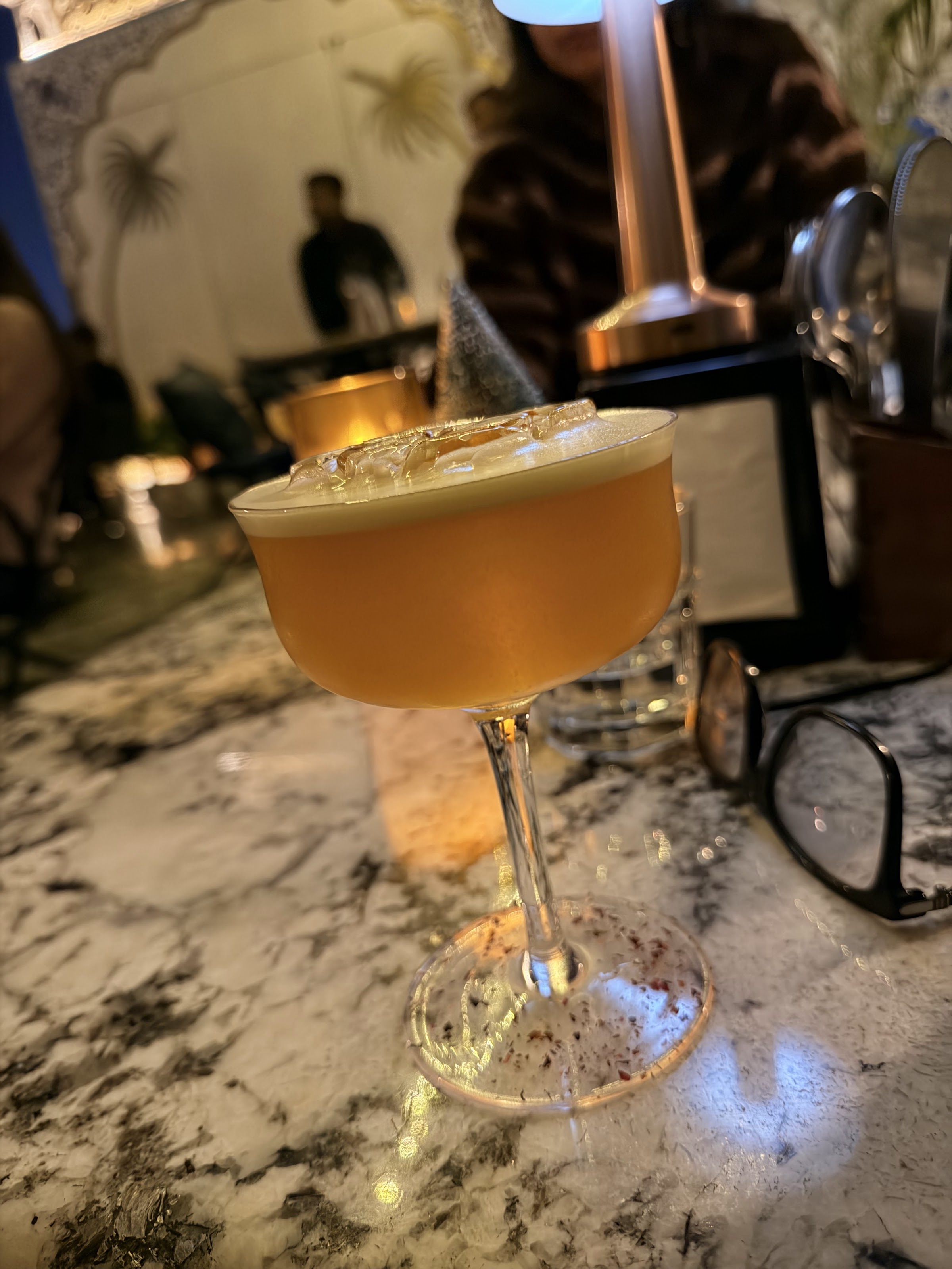 A vivid red cocktail lit by candlelight